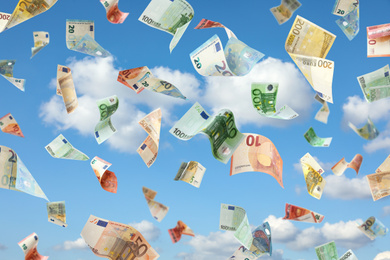 Falling Euro banknotes and blue sky on background. Money rain 