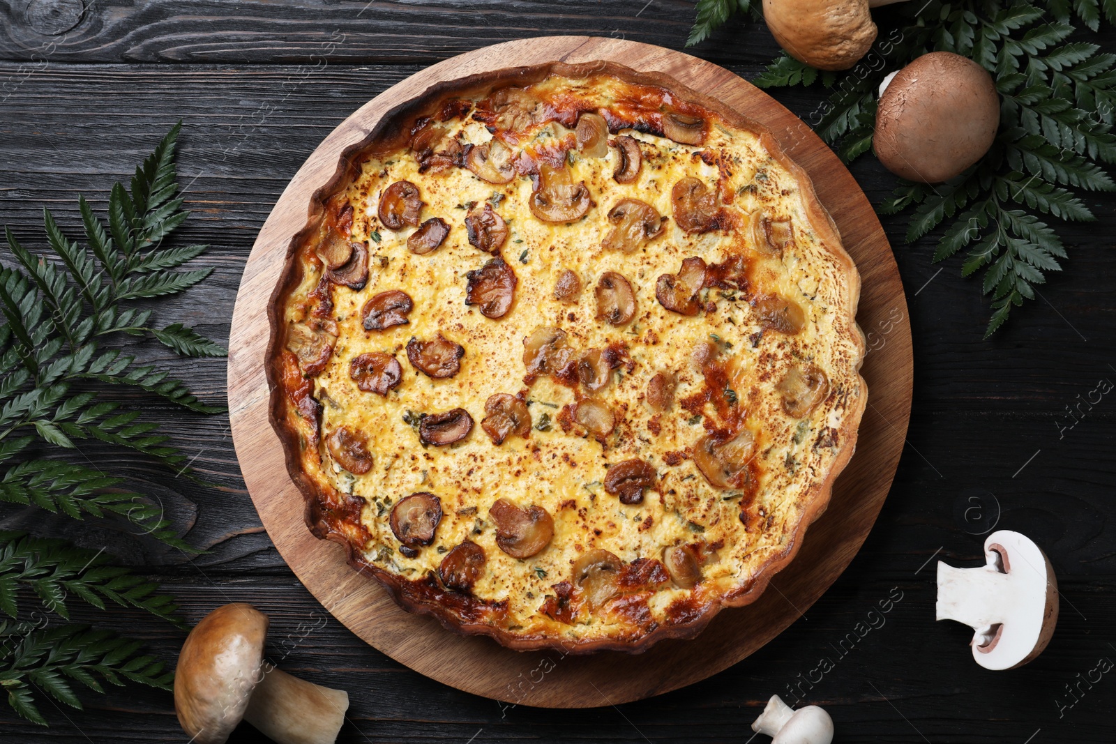 Photo of Delicious homemade mushroom pie on black wooden table, flat lay