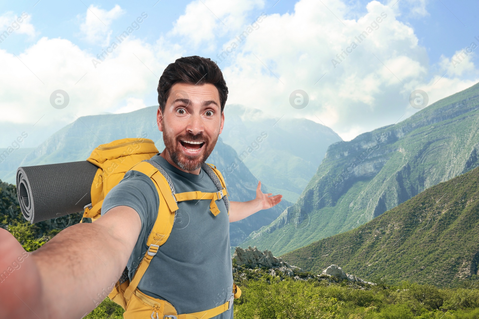 Image of Happy tourist with backpack taking selfie in mountains