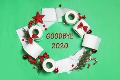 Photo of Flat lay composition with text Goodbye 2020 and toilet paper on green background, flat lay