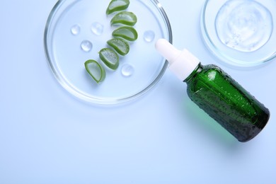 Photo of Cut aloe vera, bottle and cosmetic gel on light blue background, flat lay. Space for text