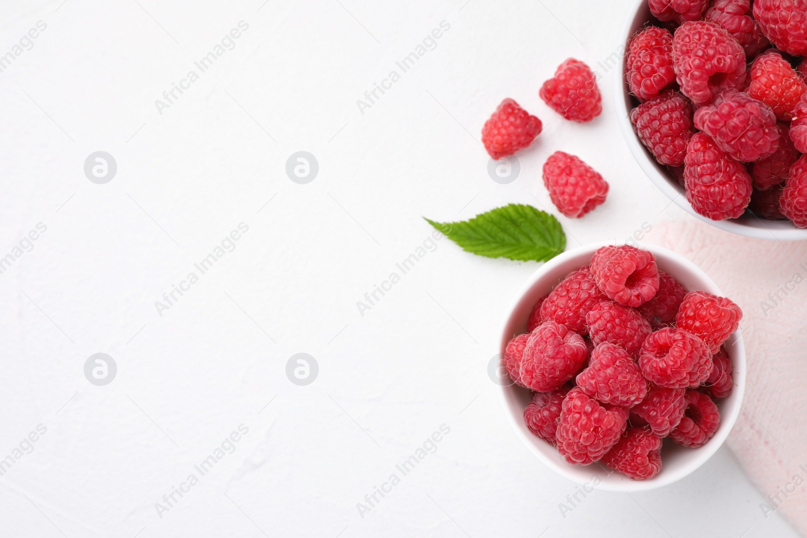 Photo of Delicious fresh ripe raspberries on white table, flat lay. Space for text