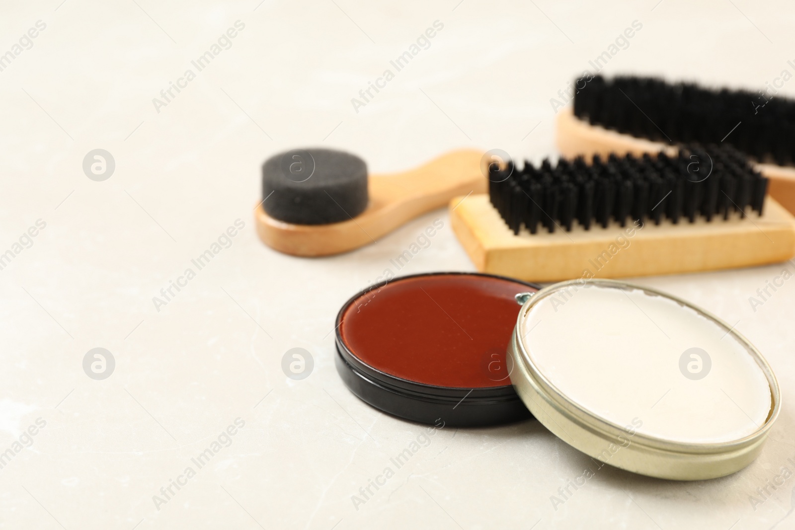 Photo of Composition with shoe care accessories on light marble background, closeup