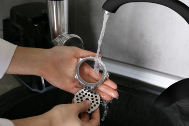 Photo of Woman washing partselectric meat grinder under tap water in kitchen sink indoors, closeup
