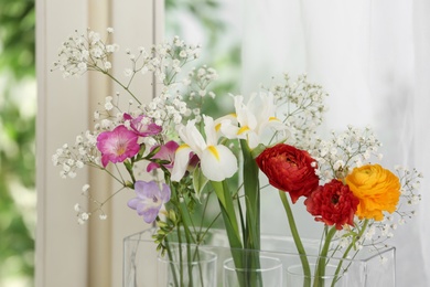 Beautiful fresh flowers near window indoors, closeup