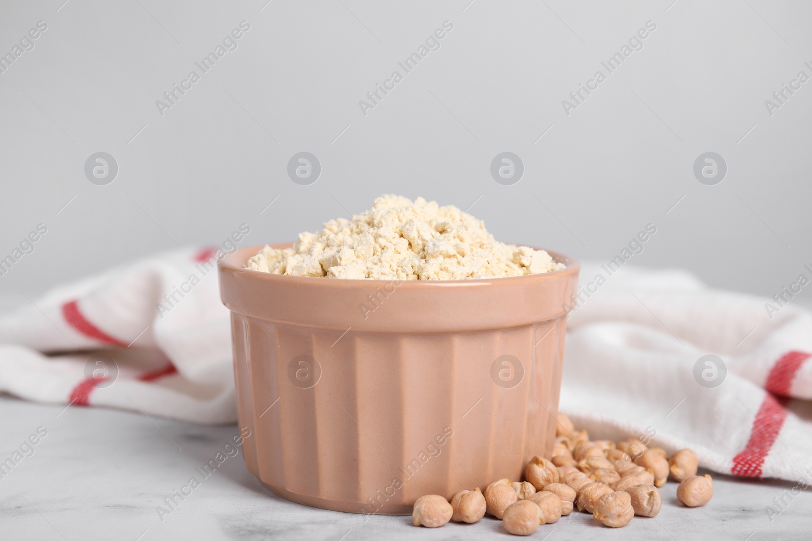 Photo of Chickpea flour in bowl and seeds on white marble table
