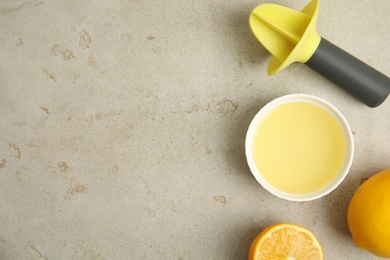 Photo of Freshly squeezed lemon juice on light grey table, flat lay. Space for text