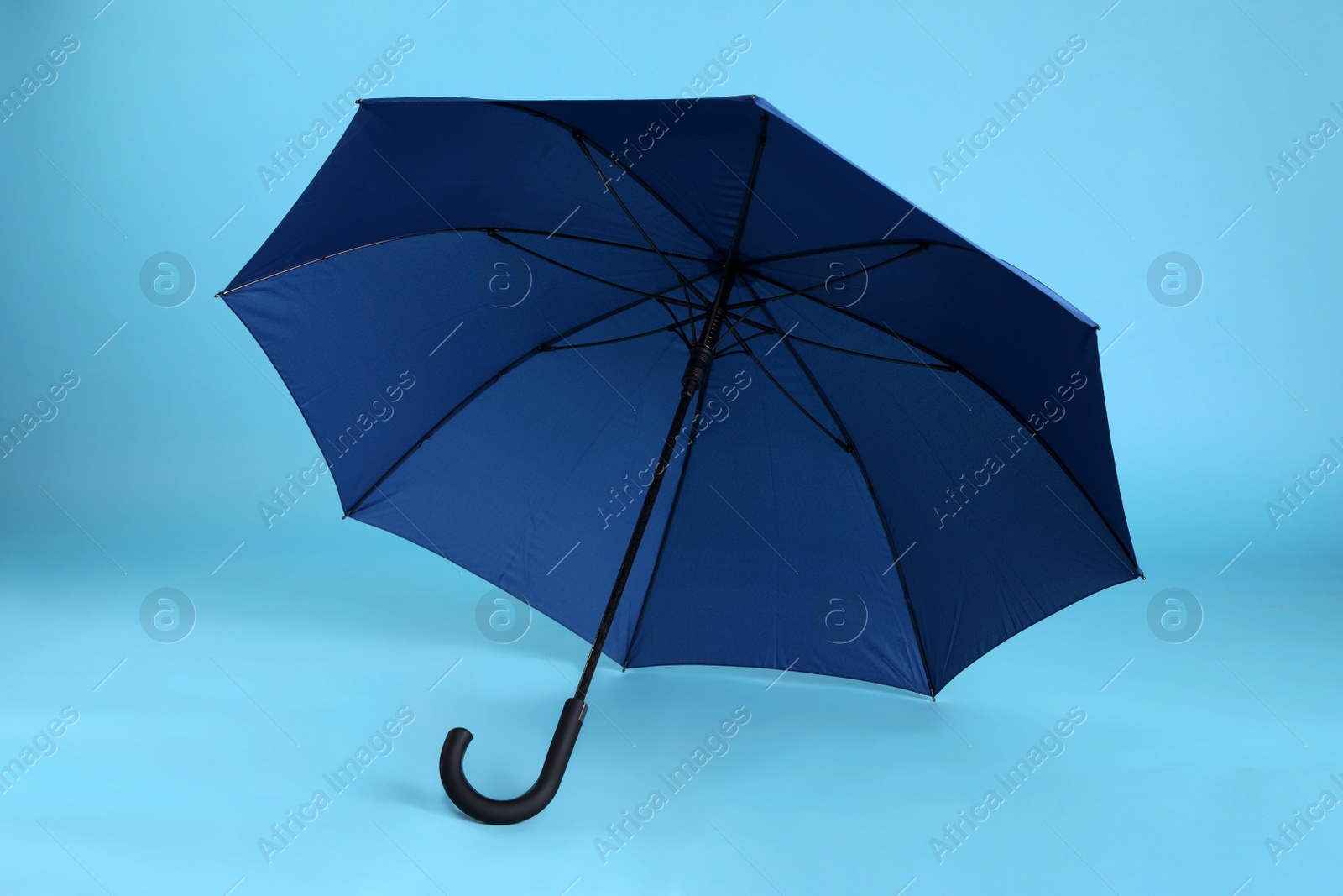 Photo of Stylish open bright umbrella on light blue background