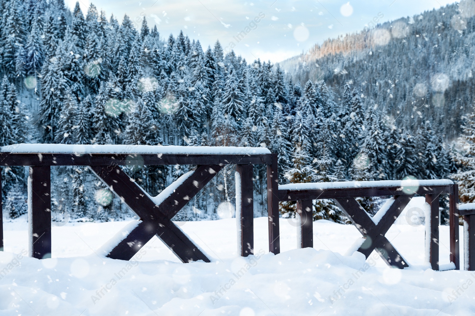 Image of Snowflakes falling on wooden fence in winter, bokeh effect