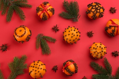 Photo of Flat lay composition with pomander balls made of fresh tangerines on red background