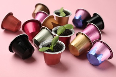 Photo of Coffee capsules and seedlings on pink background