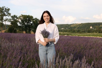 Photo of Portrait of young woman with bouquet in lavender field