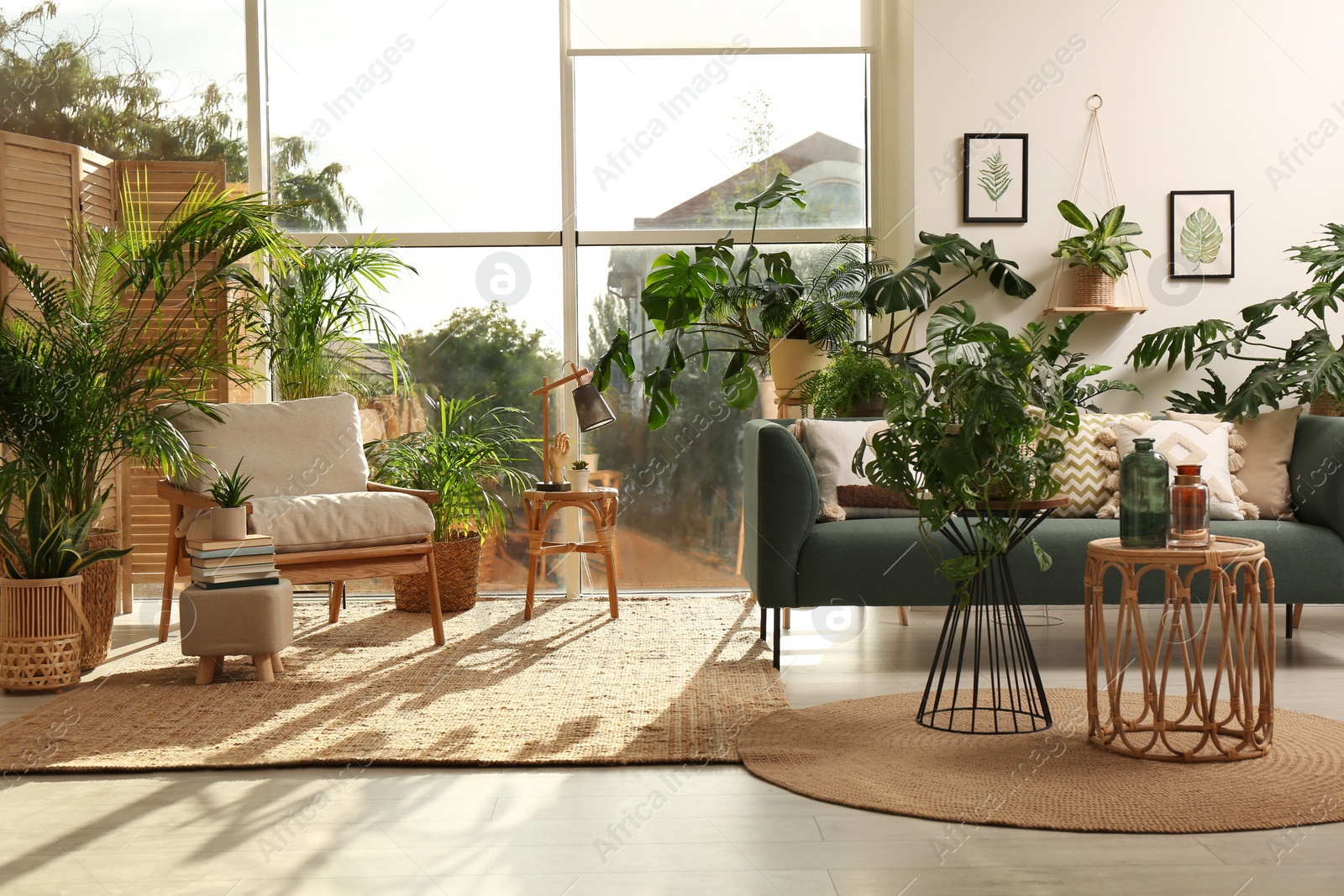 Photo of Stylish room interior with different houseplants and furniture near window