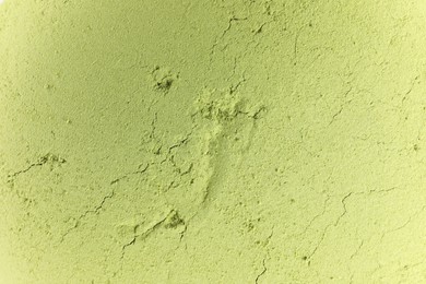 Green matcha powder as background, top view