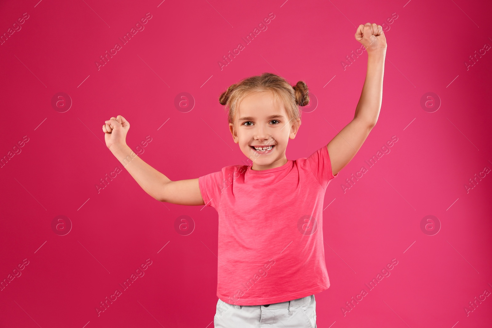 Photo of Cute little girl posing on pink background