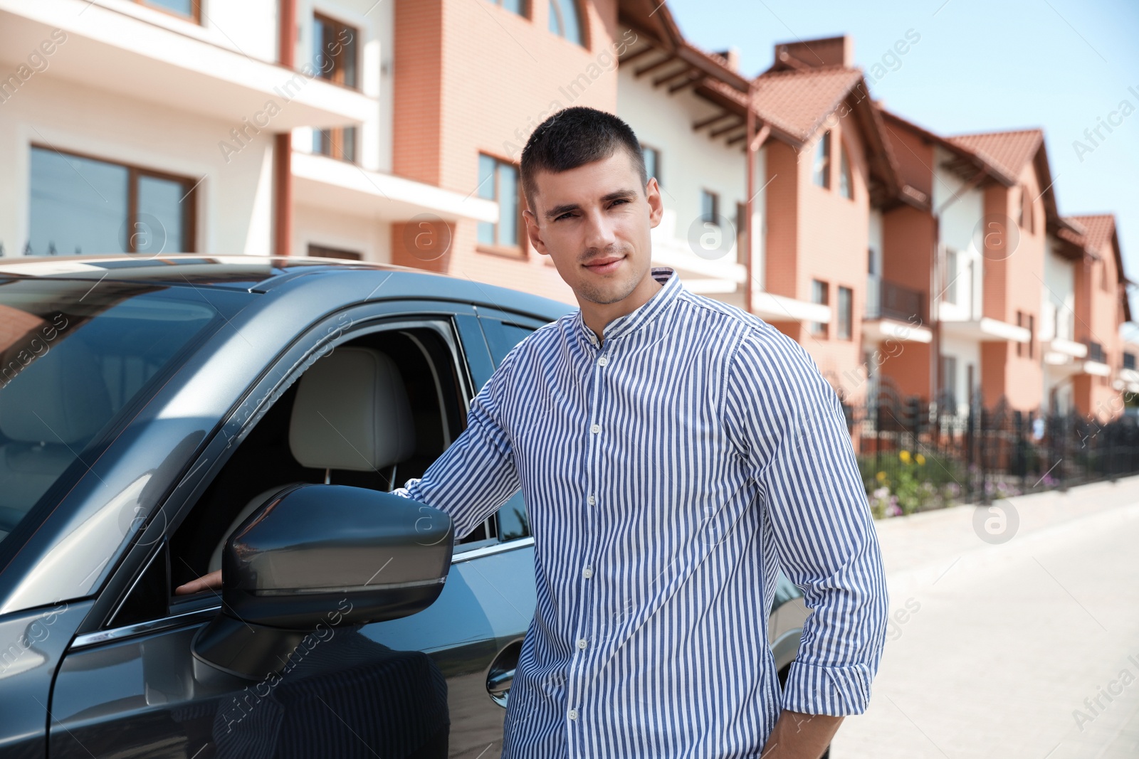 Photo of Attractive young man near luxury car outdoors