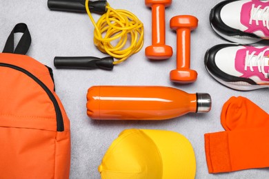 Different sports equipment on light grey table, flat lay