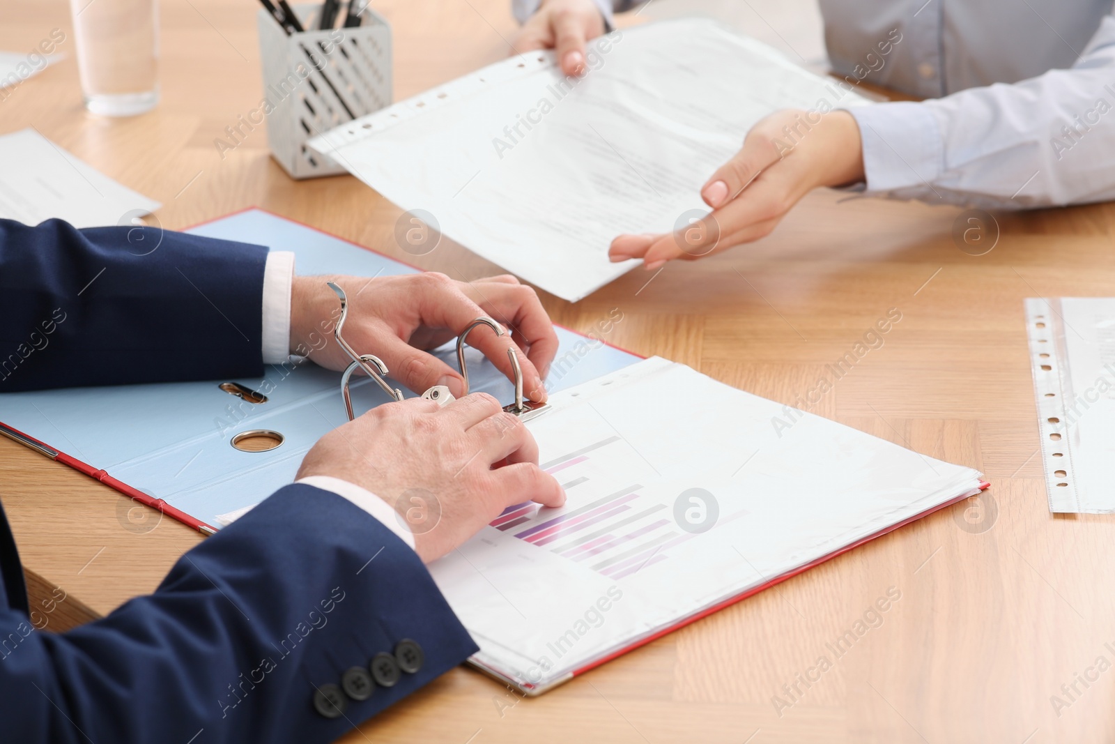 Photo of Businesspeople working with documents at wooden table in office, closeup