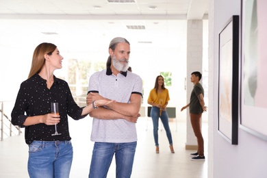 Senior man and woman at exhibition in art gallery