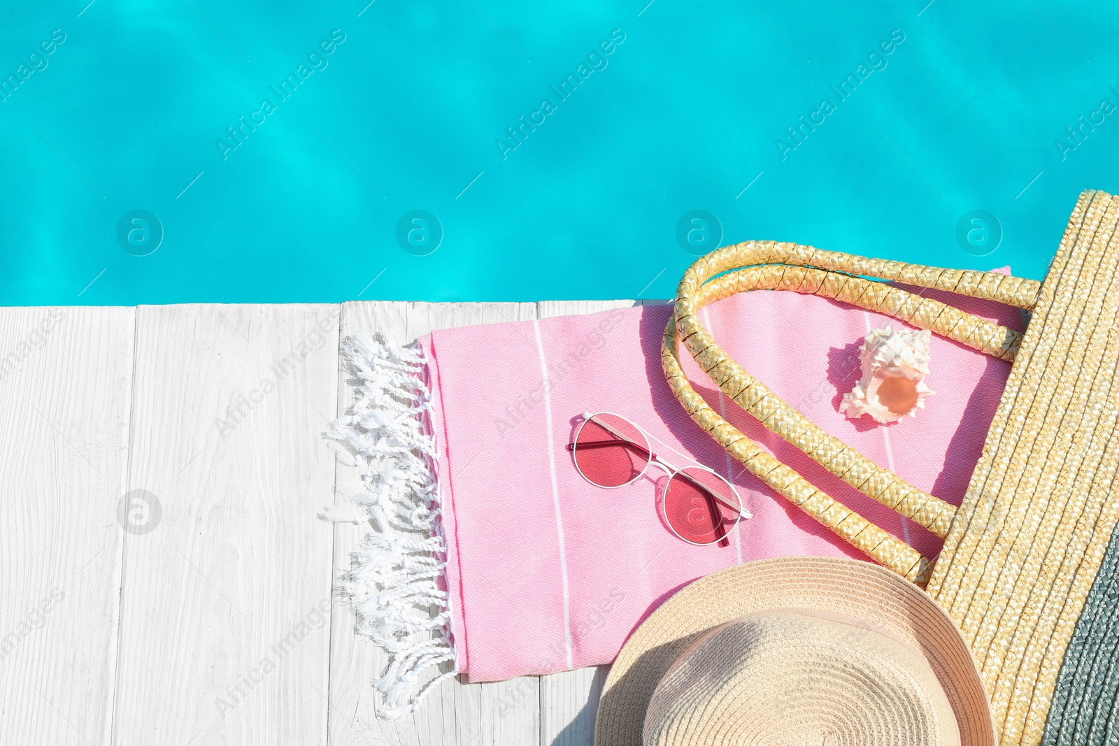 Photo of Flat lay composition with beach accessories on wooden deck near swimming pool. Space for text