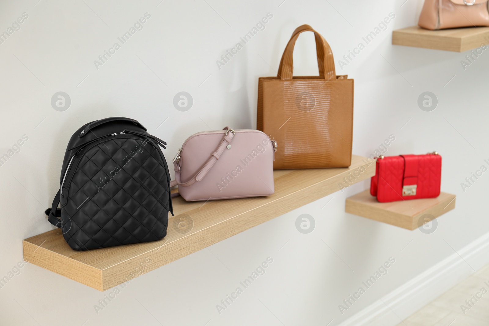 Photo of Stylish woman's bags on shelf in boutique
