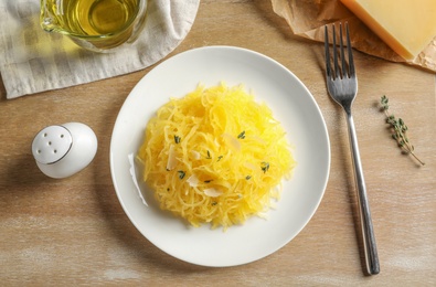 Flat lay composition with cooked spaghetti squash on wooden table