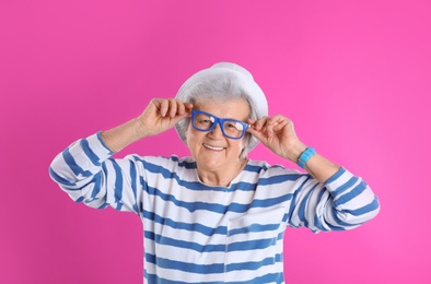 Photo of Portrait of cool grandmother on color background