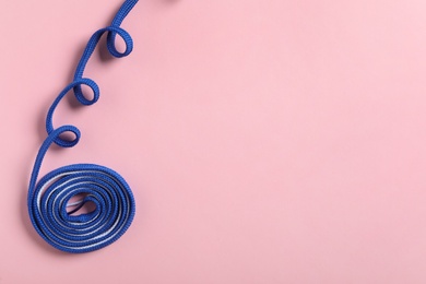 Blue shoelace on pink background, top view. Space for text