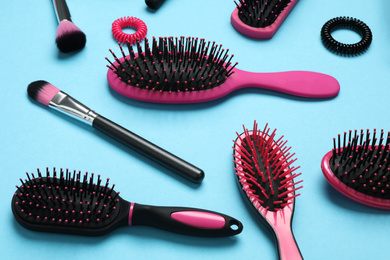 Photo of Composition with modern hair brushes on light blue background, above view