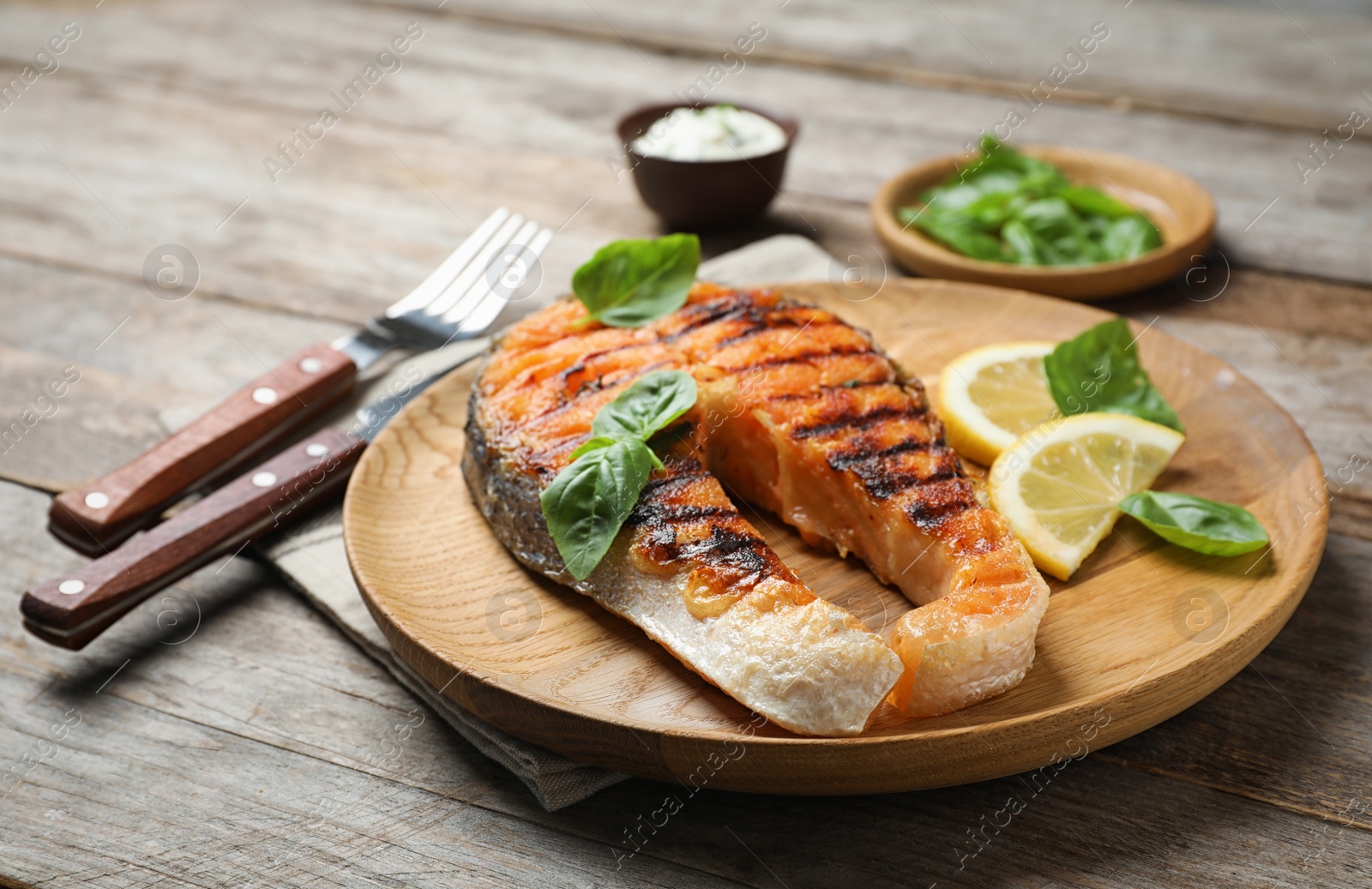 Photo of Plate with tasty salmon steak on wooden table