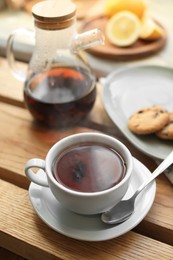 Photo of Cup with delicious tea on wooden table