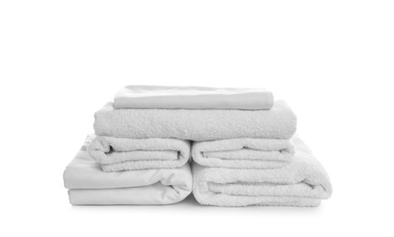 Stack of towels and bedding on white background