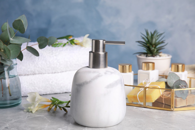 Photo of Marble soap dispenser and toiletries on grey table