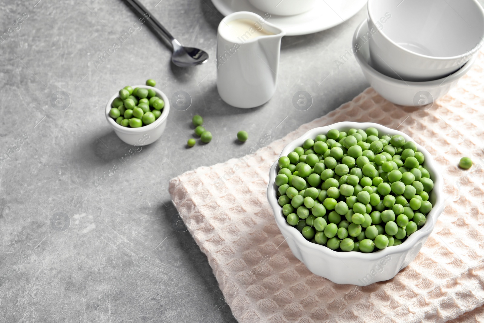 Photo of Bowl with delicious fresh green peas on table