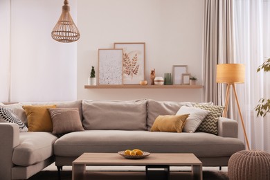 Photo of Stylish living room interior with comfortable grey sofa and coffee table