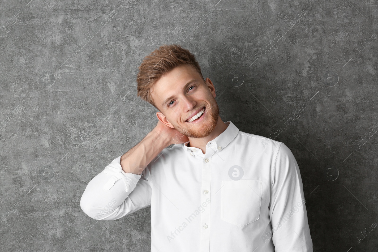 Photo of Portrait of handsome young man near grey wall