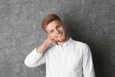 Photo of Portrait of handsome young man near grey wall