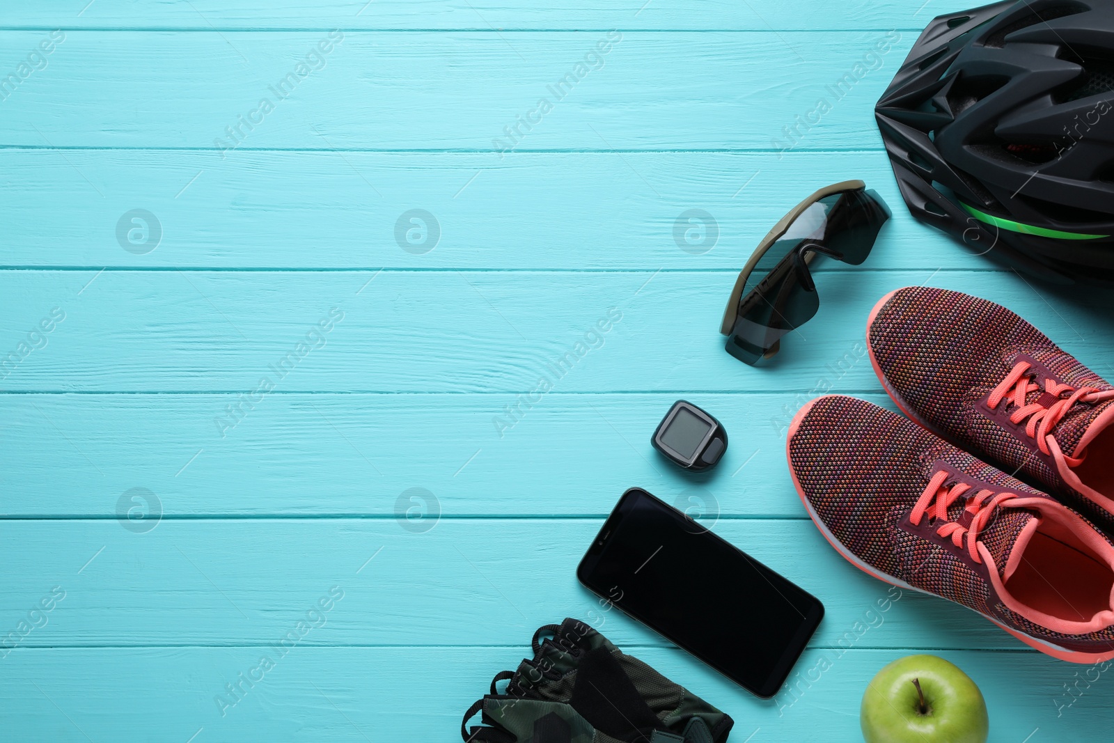 Photo of Flat lay composition with different cycling accessories on turquoise wooden background, space for text