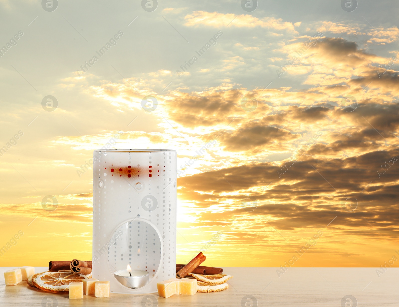 Image of Composition with aroma lamp on wooden table outdoors at sunset, space for text