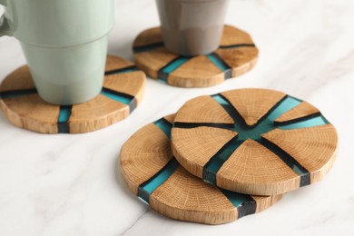 Photo of Stylish wooden cup coasters on white table