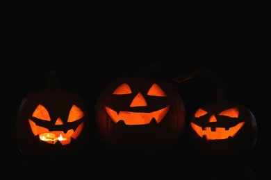 Photo of Halloween pumpkin heads. Glowing jack lanterns in dark