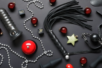 Set of different sex toys and Christmas decorations on black background, flat lay