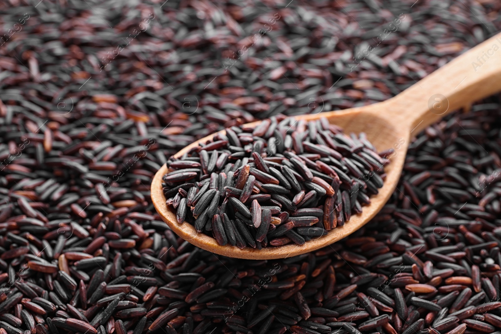 Photo of Pile of brown rice with spoon, closeup, closeup