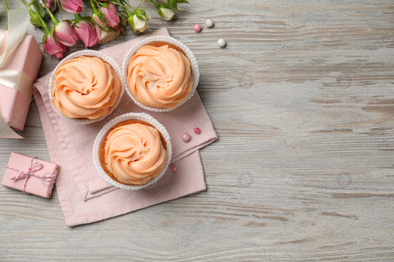 Photo of Flat lay composition with tasty cupcakes on white wooden table. Space for text