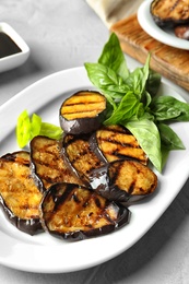 Plate with fried eggplant slices on table, closeup