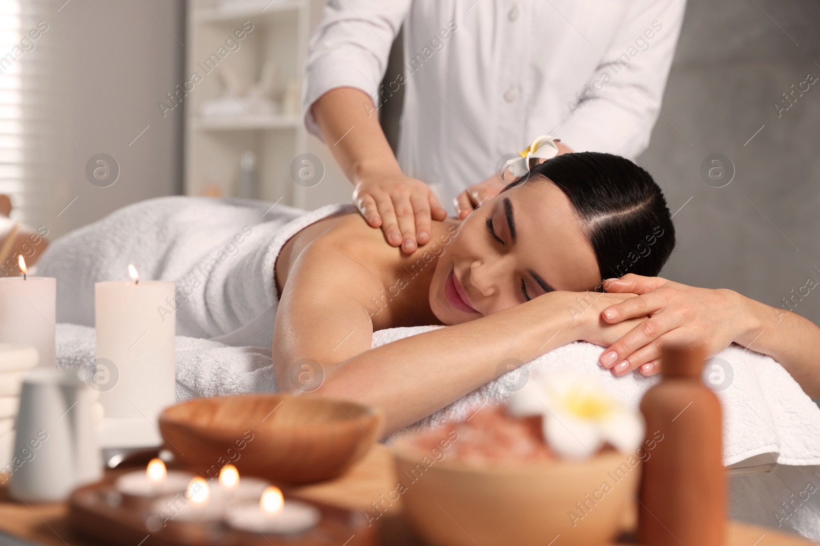 Photo of Beautiful woman receiving back massage in beauty salon, closeup