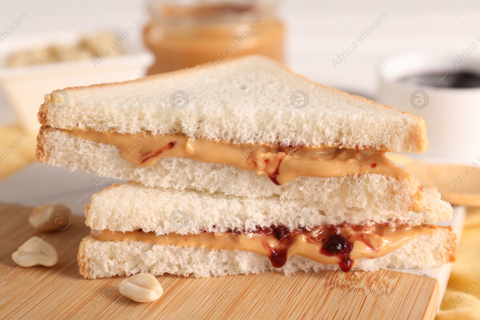 Photo of Sandwich with tasty nut butter and jam on wooden board, closeup