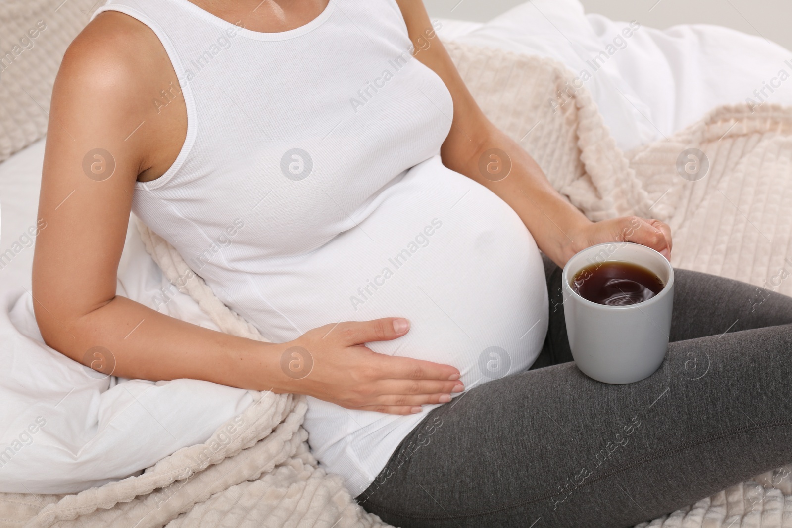 Photo of Pregnant woman drinking tea at home, closeup