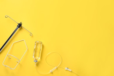 Photo of IV infusion set on yellow background, flat lay. Space for text