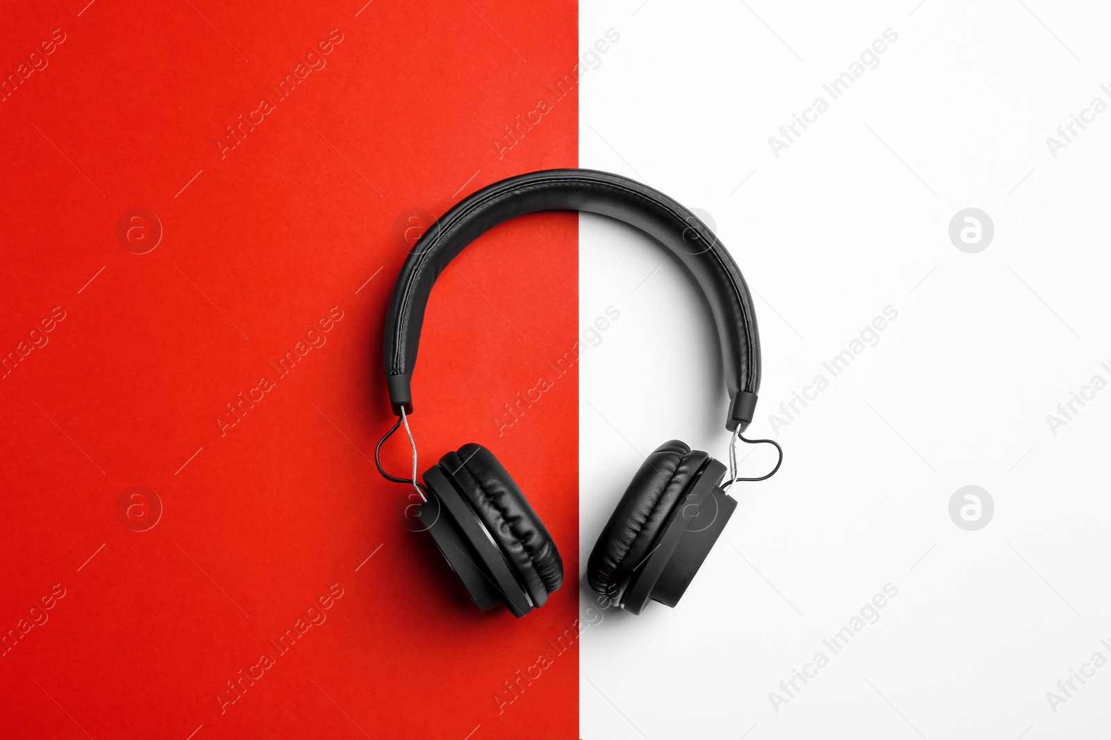 Photo of Stylish headphones on color background, top view